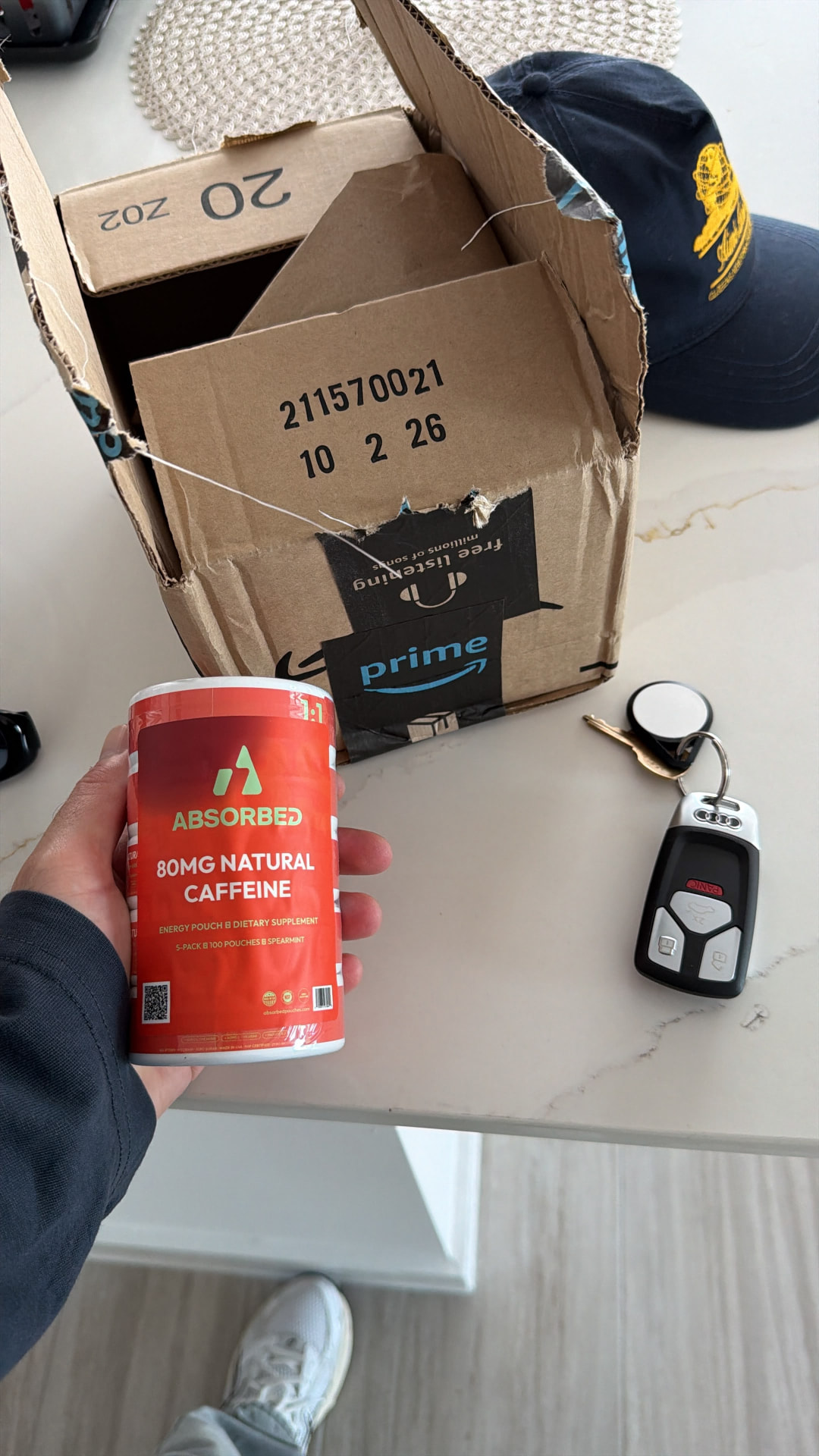 ABSORBED five-pack held beside an opened delivery box