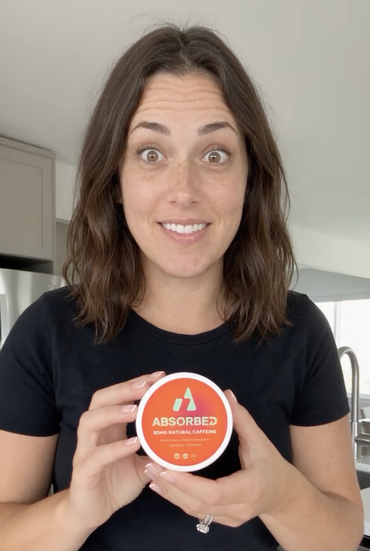 Person holding an ABSORBED spearmint tin at home